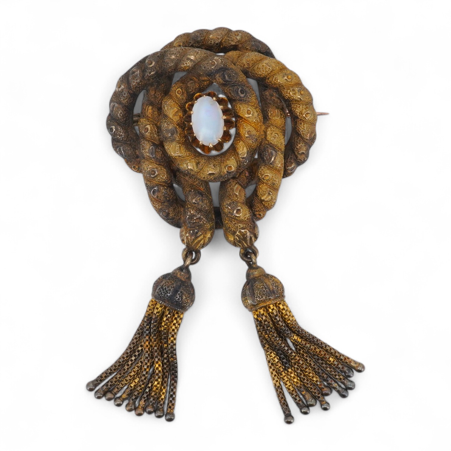 A Victorian opal brooch, mid 19th century, of knotted design in textured gold, set with a cabochon opal, suspending two tassels, length 7cm, gross weight 14 grams